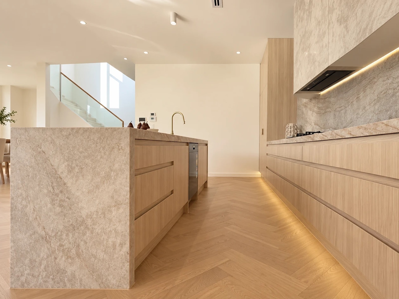 Kitchen galley along a long island run, herringbone oak flooring